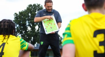 A coach in Norwich City kit takes a session