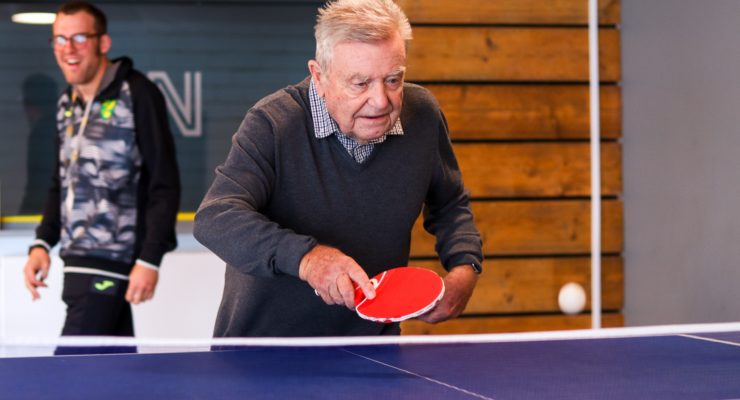 An older person tries table tennis