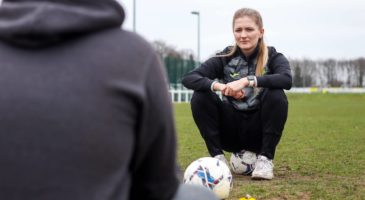 Maya sitting on football chatting to Tyler