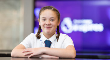 Smiling girl sitting down.