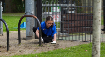 Girl weeding a pathway.