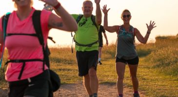 three people walking and waving