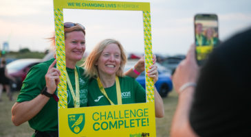 two men posing with 'challenge complete' sign