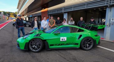 Group of people standing behind green car
