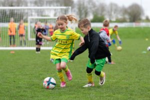 Boy and girl playing football