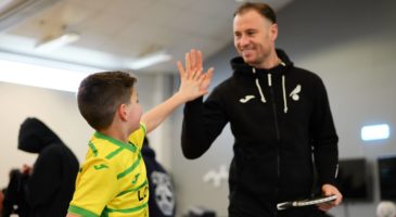 Ashley Barnes high-fives young participant