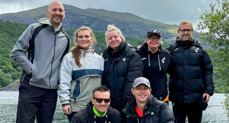 Team at the bottom of a mountain