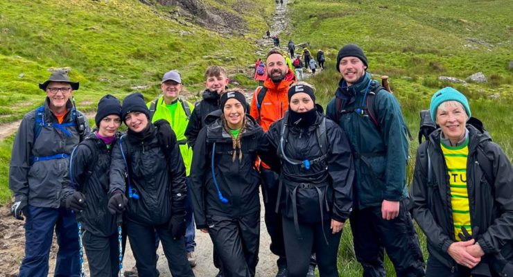 Team at the bottom of a mountain