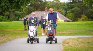 Two men walking with their golf trolleys