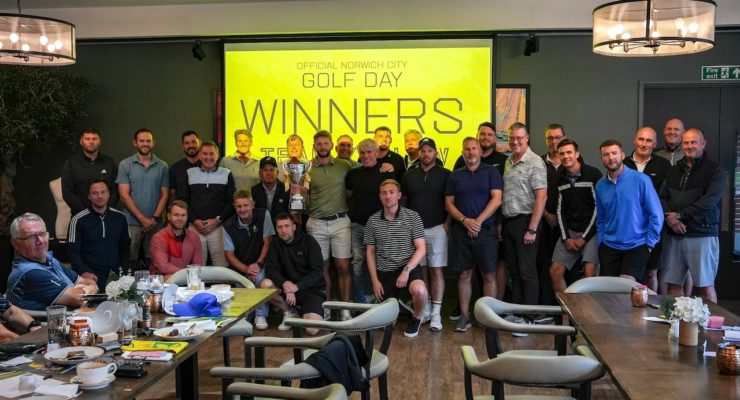 Group of people standing in front of a screen that says winners