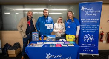 Man and women standing in front of charity collateral