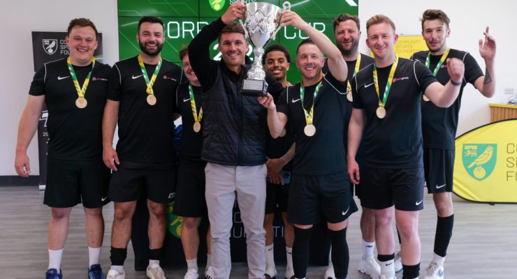 team in black football kit lifting the trophy