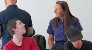 a woman in blue top talking to a man in a red top
