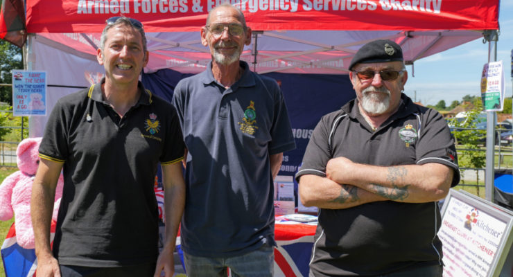 three men standing in front of a gazebo