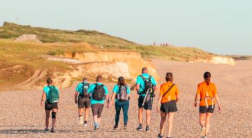 view of a group of people walking along a beach away from the camera