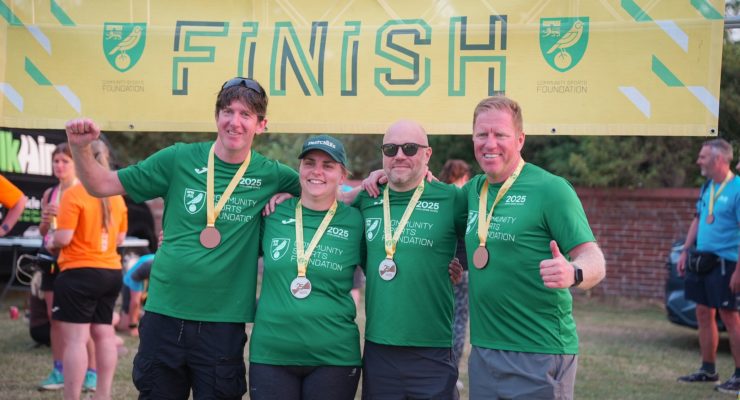 four people in green tshirt in front of a finish sign