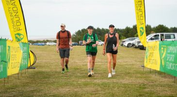 three people walking to the finish line