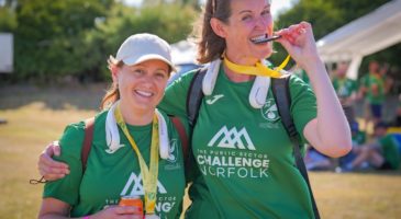 two women in green tshirts with wooden medals