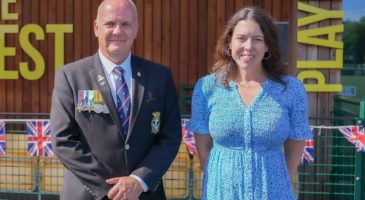man with medals on jacket and women in blue dress