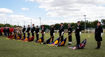 military personnel with flags lowered on parade