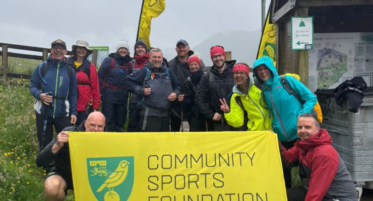 Group of people with flag saying community sports foundation 