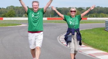 Two people walking with hands in the air