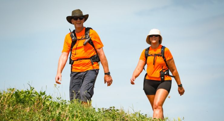 two people in orange tshirts walking