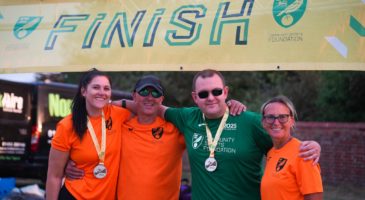 Group of people underneath finish banner