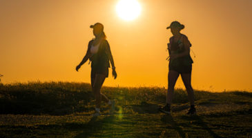 Two people walking at sunrise