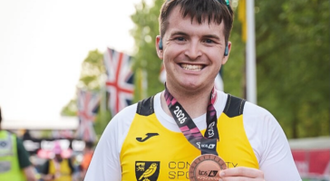 man in yellow top with medal round his neck