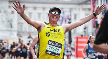 man in yellow vest with his arms open