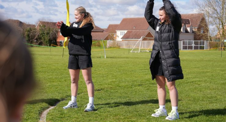 two women in black cheering clapping and raising their hands