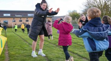 two women giving high fives to children 