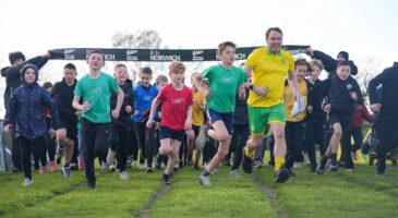 children and an adult running on grass