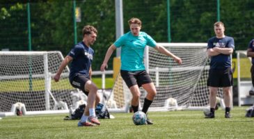 three men playing football