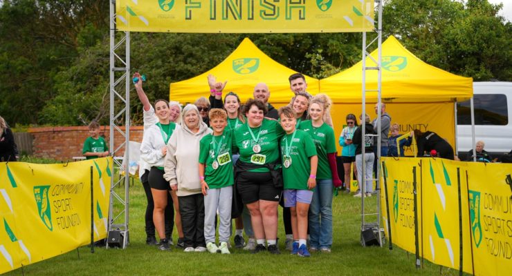 Group of people standing underneath finish banner