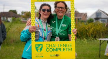 two women in hold a frame saying challenge complete