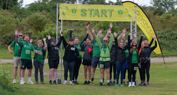 group of people standing underneath a start banner