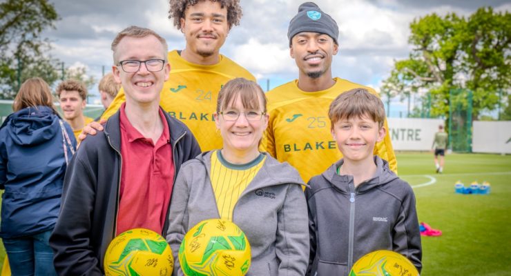 two norwich city players with three fans