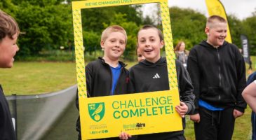 two children behind a sign saying challenge complete