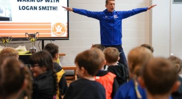 man in blue top holding out his arms