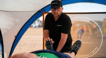 a man holding onto a foot, giving a massage