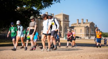 Group of people walking with Holkham Hall in the background
