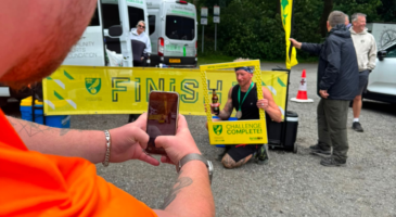 a man having his photo taken behind a frame that says challenge complete